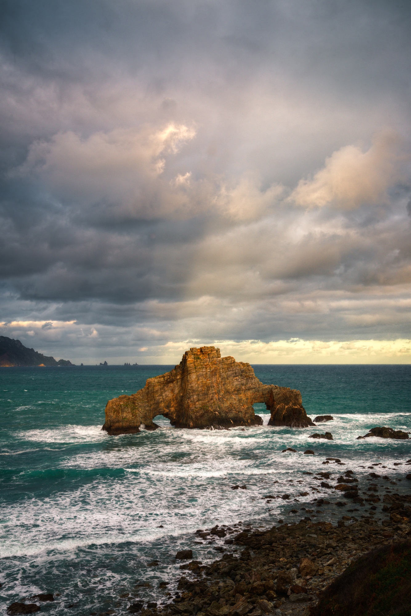 The rays of the rising sun briefly illuminate the clouds in Cabo Ortegal Unesco Geopark